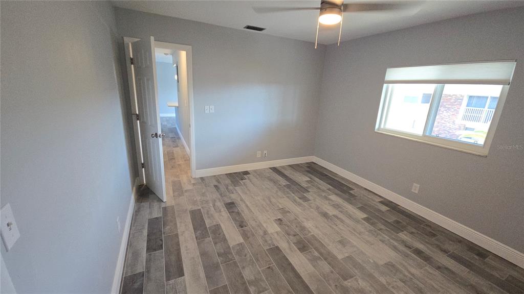 3755 South School Avenue, Unit 42 Sarasota, FL 34239 - Photo 12 of 22 an empty room with wooden floor and windows