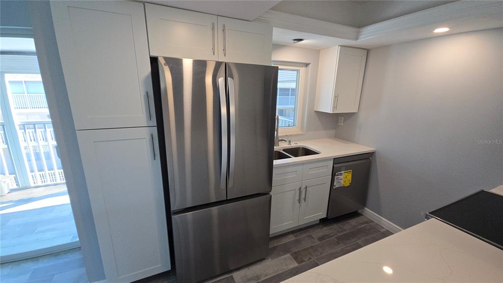 3755 South School Avenue, Unit 42 Sarasota, FL 34239 - Photo 5 of 22 a kitchen with a refrigerator sink and cabinets