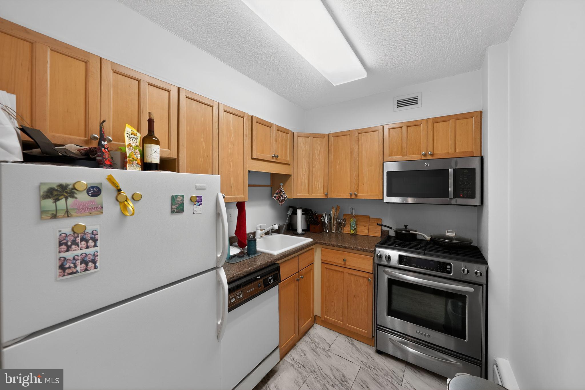 429 N Street Southwest, Unit S210 Washington, DC 20024 - Photo 3 of 16 a kitchen with a refrigerator a stove top oven a sink and cabinets