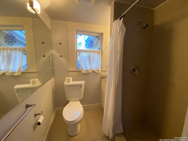 a white toilet sitting next to a bathroom sink and tub
