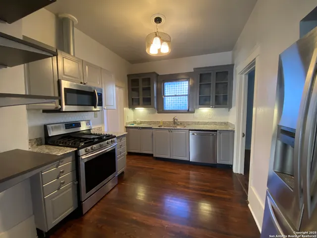 a kitchen with stainless steel appliances granite countertop a stove a sink and a refrigerator
