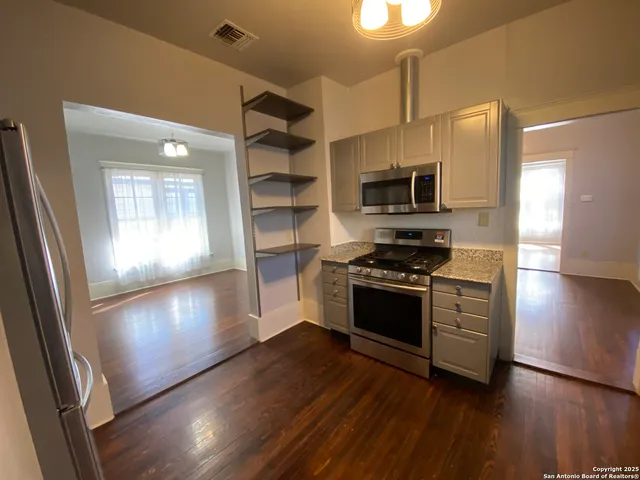 a kitchen with granite countertop a stove and a refrigerator