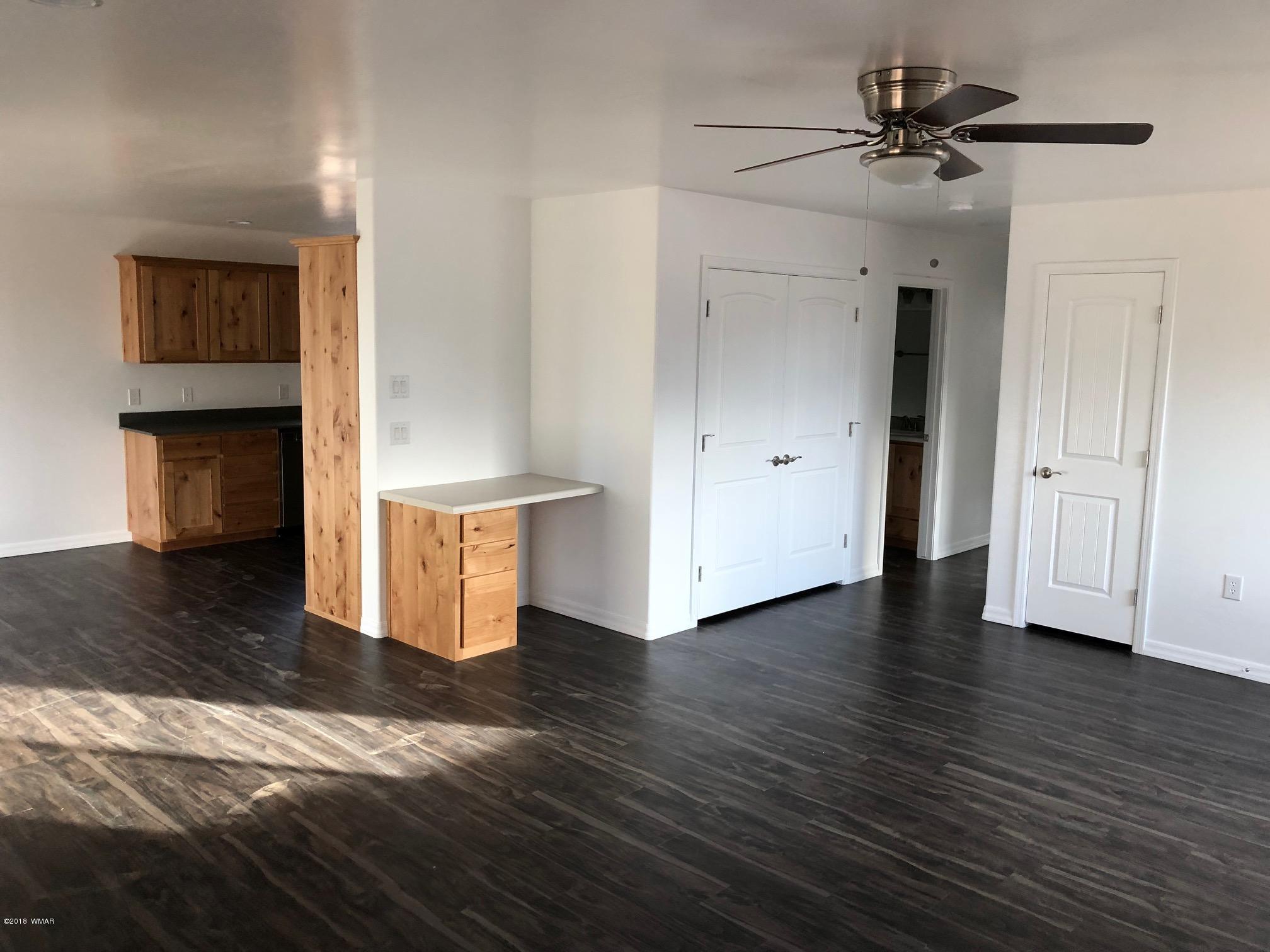 345 South 5th W Street Snowflake, AZ 85937 - Photo 8 of 11 a view of an empty room with wooden floor and a ceiling fan