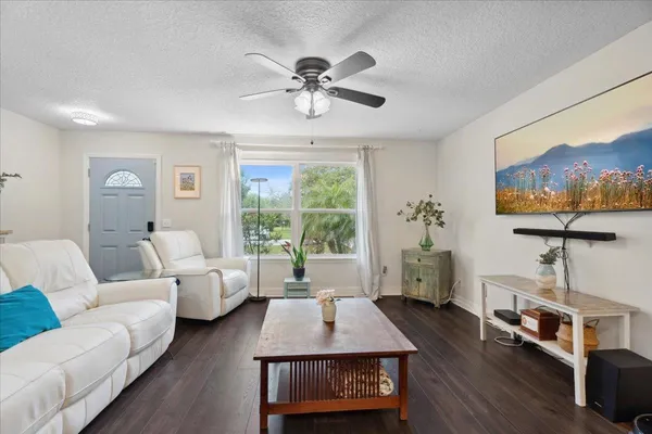 a living room with furniture a chandelier and a window