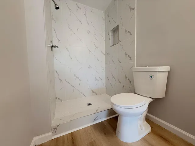a bathroom with a toilet and a shower