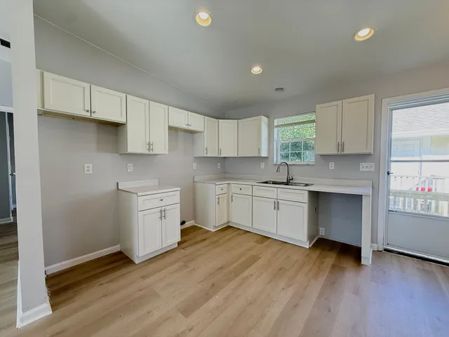 a kitchen with granite countertop white cabinets and white appliances