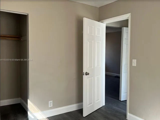 an empty room with wooden floor and closet