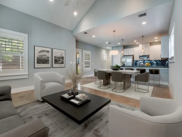 a living room with stainless steel appliances furniture and a potted plant