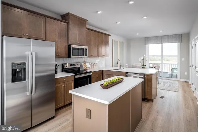 a kitchen with a sink a counter top space stainless steel appliances and cabinets