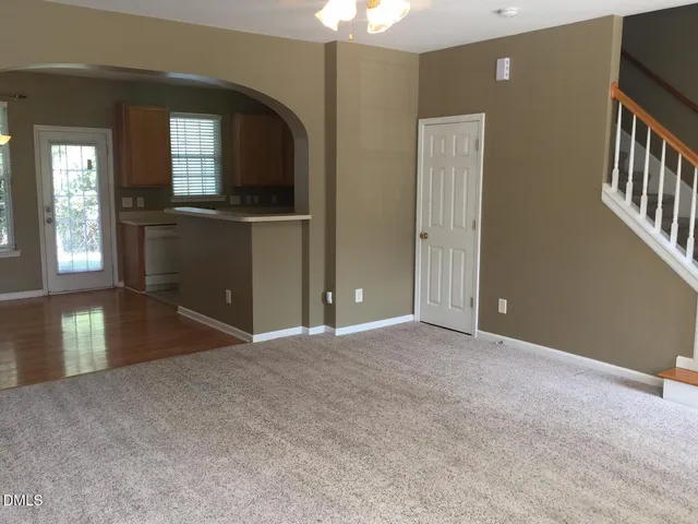 a view of an empty room with a fireplace and a chandelier