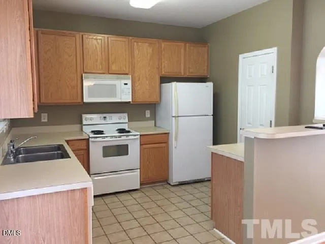 a kitchen with a refrigerator sink stove and cabinets