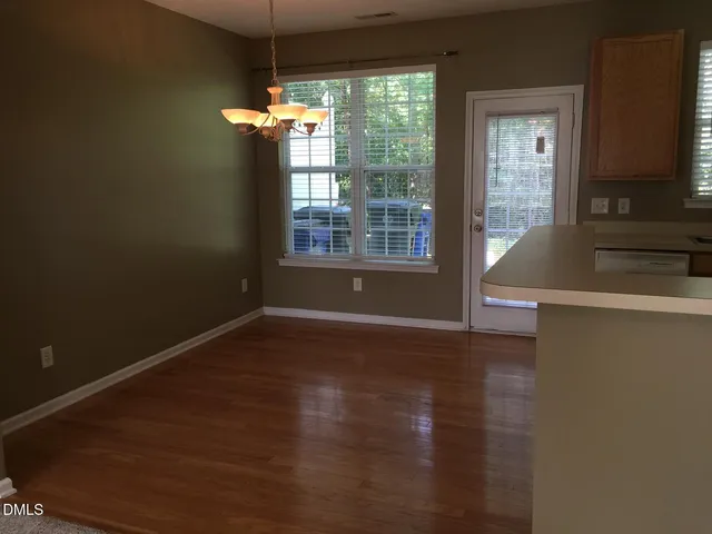 a view of a room with wooden floor and a window