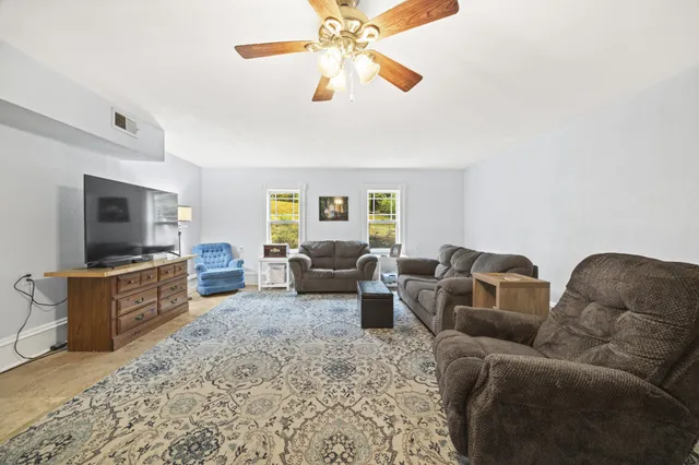 a living room with furniture flat screen tv and couches