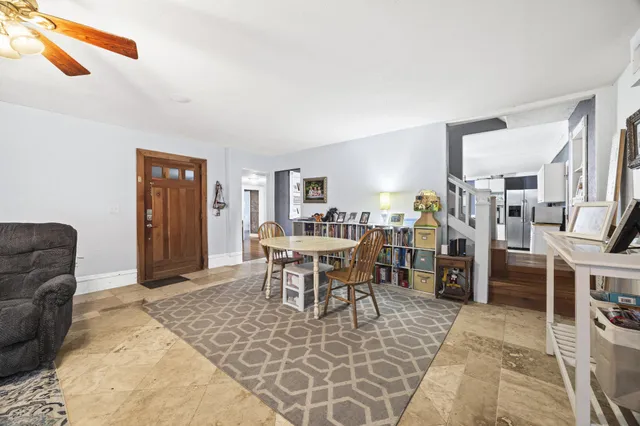 a living room with furniture a large window and kitchen view