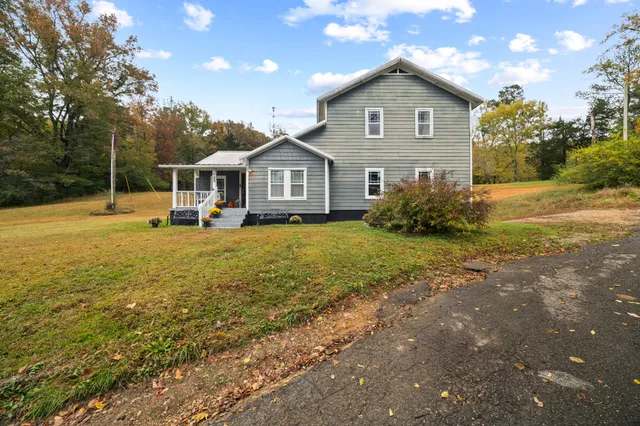 a front view of a house with a yard and trees