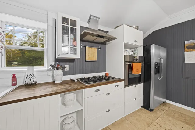 a kitchen with stainless steel appliances granite countertop a sink and a stove next to a window