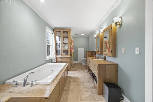 a bathroom with a granite countertop tub sink and mirror