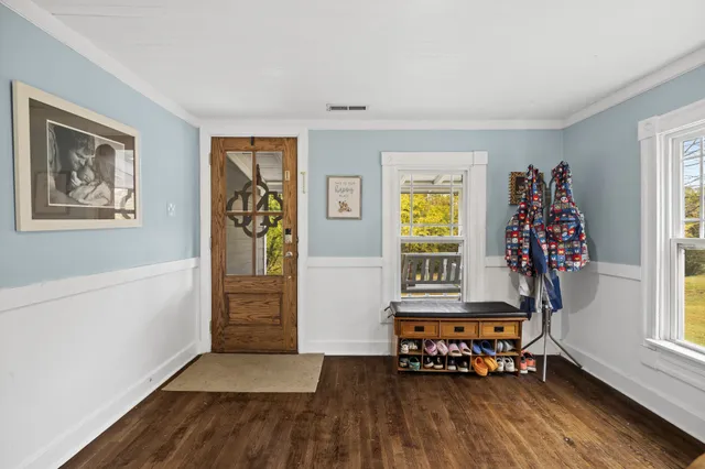 a hallway with wooden floor windows and chandelier