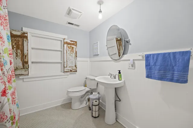 a bathroom with a toilet sink and mirror