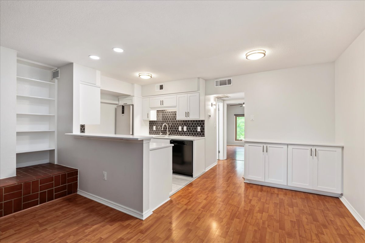 505 West 7th Street, Unit 313 Austin, TX 78701 - Photo 4 of 30 Kitchen featuring light wood-style floors, dishwasher, visible vents, and white cabinetry