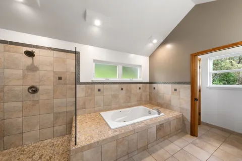a bathroom with a granite countertop double vanity sink a mirror and a shower