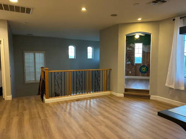 a view of a hallway with wooden floor and staircase