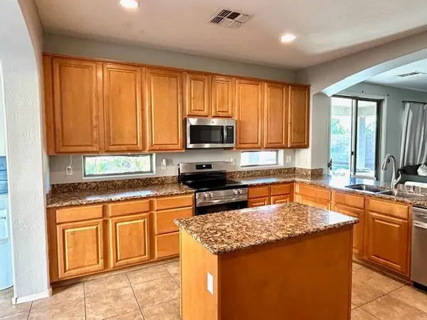 a kitchen with stainless steel appliances granite countertop a refrigerator and a stove