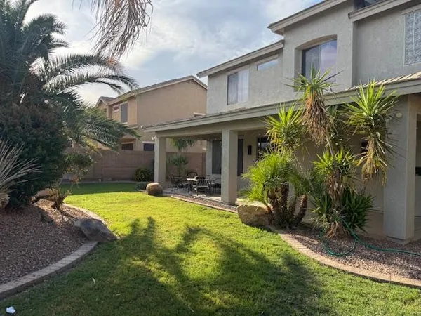 a view of a house with backyard and sitting area