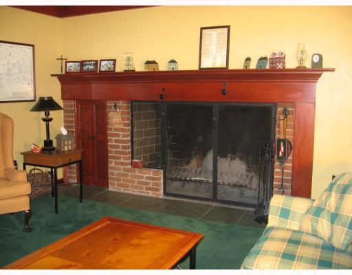 140 Witherow Road Bell Acres, PA 15143 - Photo 5 of 8 Den/Family/Great Room. A wood and brick colonial-style fireplace in the family room is complemented by stained baseboards and moldings; wood can be readily accessible in the small cupboard. A sliding door opens to a large deck with some trellising.