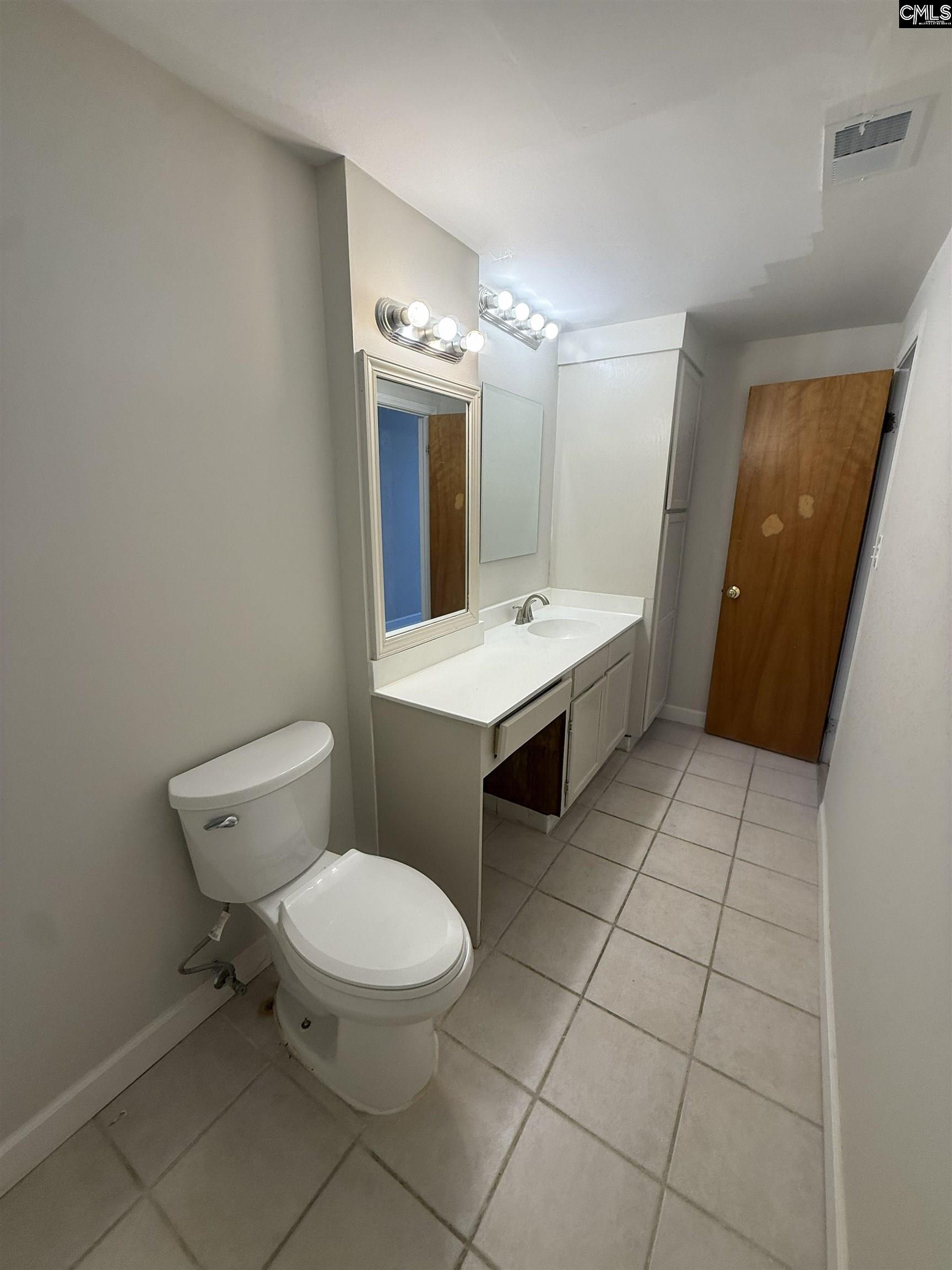 2002 Greene Street, Unit 209 Columbia, SC 29205 - Photo 8 of 22 a bathroom with a toilet a sink and mirror