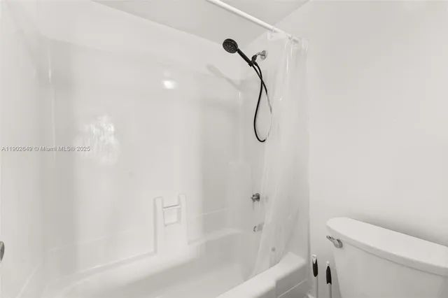 a bathroom with a shower and a white bath tub