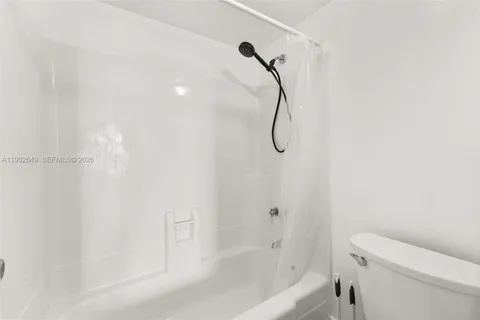 a bathroom with a shower and a white bath tub