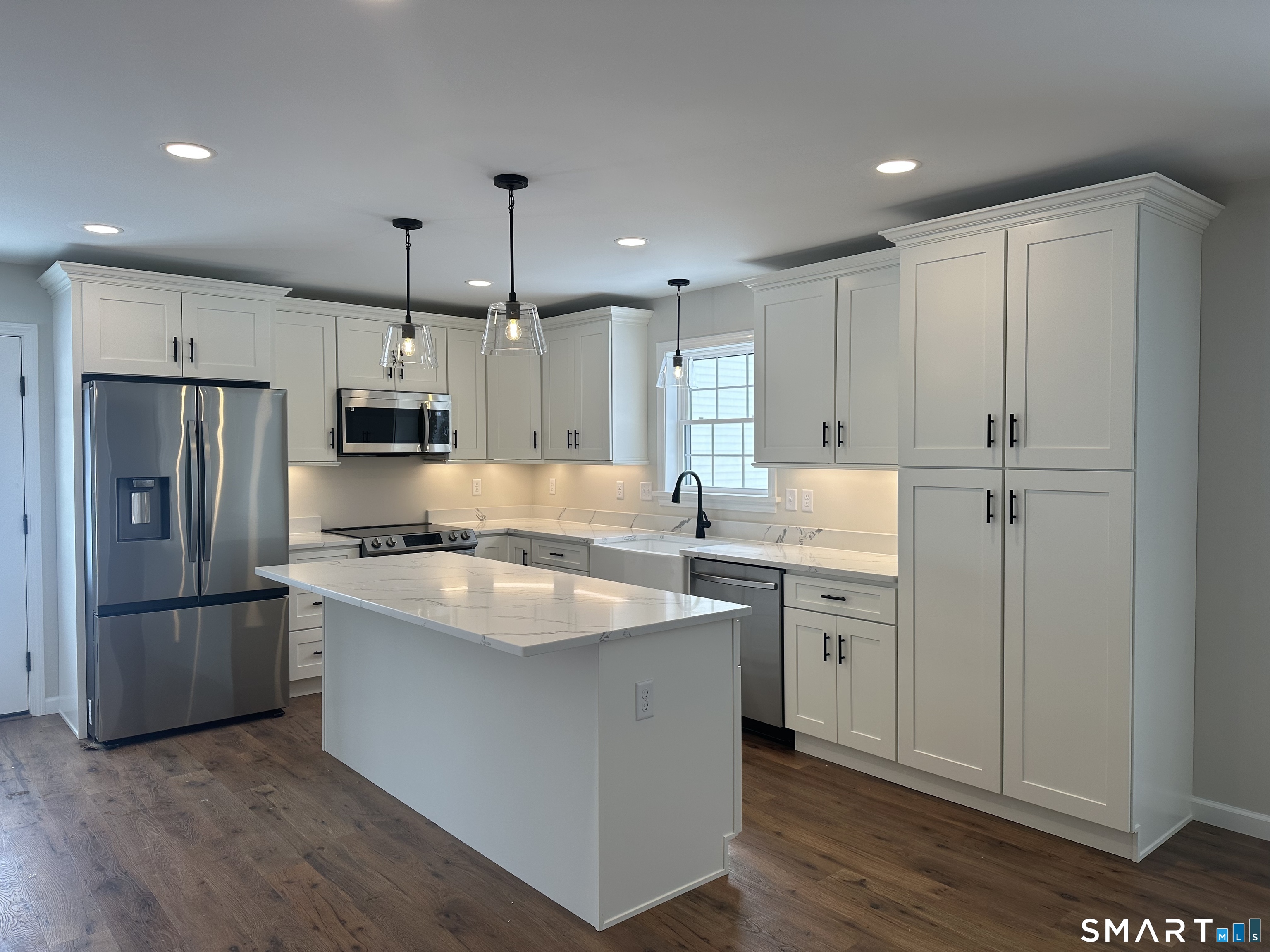 277 Moosup Pond Road Plainfield, CT 06354 - Photo 24 of 25 a kitchen with stainless steel appliances granite countertop a refrigerator a sink dishwasher a stove and white countertops with wooden floor