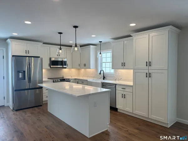a kitchen with a refrigerator and a stove top oven
