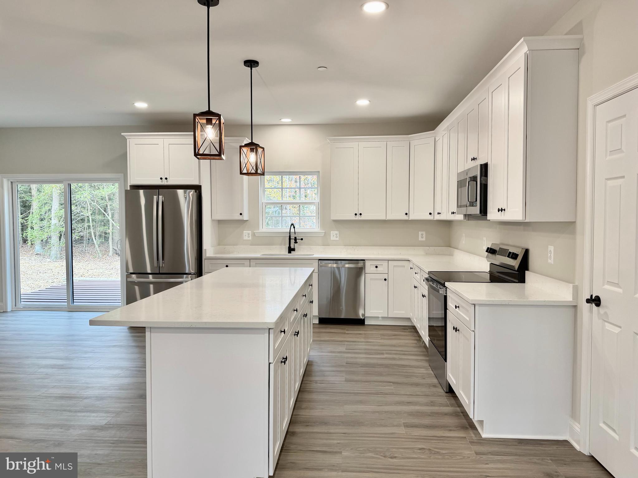 44968 Hewitt Road Callaway, MD 20620 - Photo 4 of 33 a kitchen with kitchen island a sink a stove a refrigerator and white cabinets