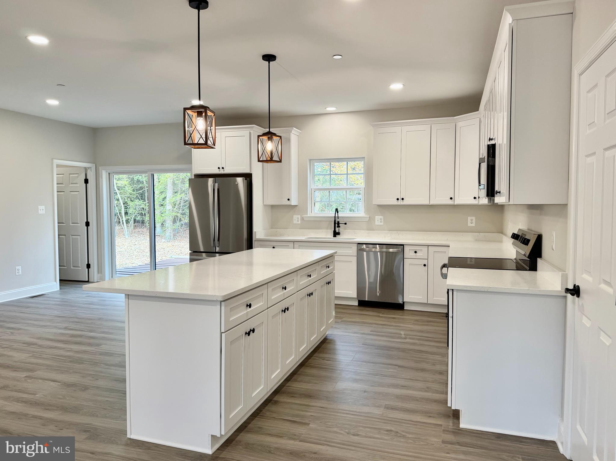44968 Hewitt Road Callaway, MD 20620 - Photo 6 of 33 a kitchen with kitchen island granite countertop white cabinets stainless steel appliances a sink and a window