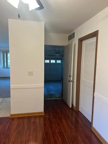 an empty room with wooden floor and entrance