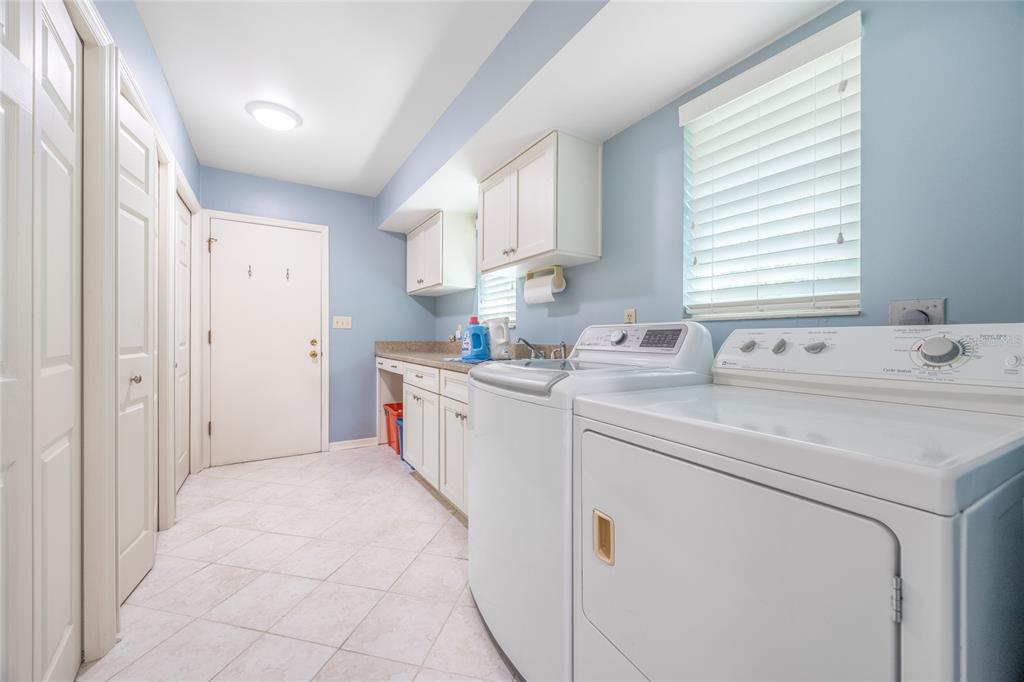 5808 Southwest 35th Way Gainesville, FL 32608 - Photo 38 of 54 a utility room with cabinets washer and dryer