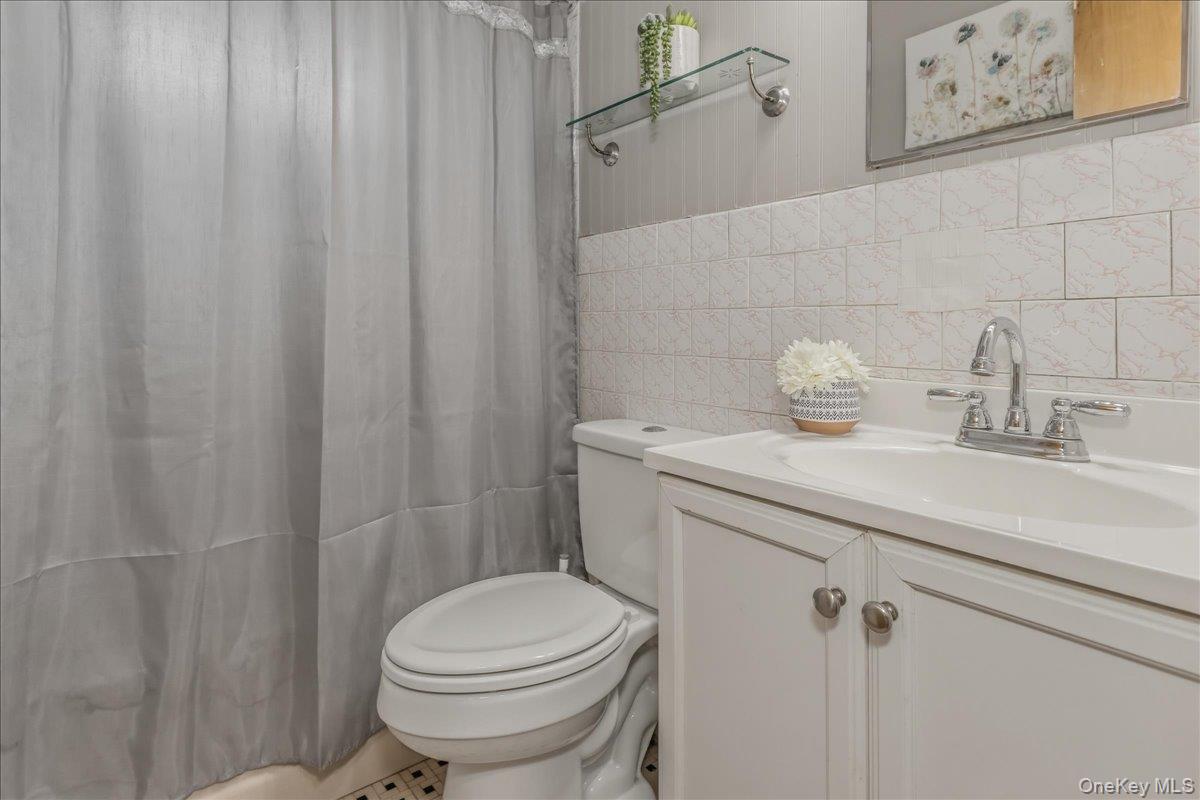 86 Oceanview Avenue Valley Stream, NY 11581 - Photo 12 of 21 a bathroom with a sink a toilet and shower curtain