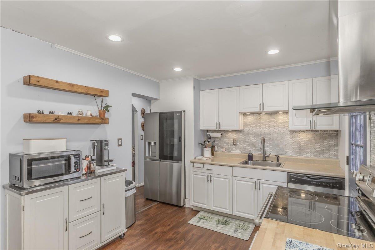 86 Oceanview Avenue Valley Stream, NY 11581 - Photo 9 of 21 a kitchen with refrigerator cabinets and wooden floor
