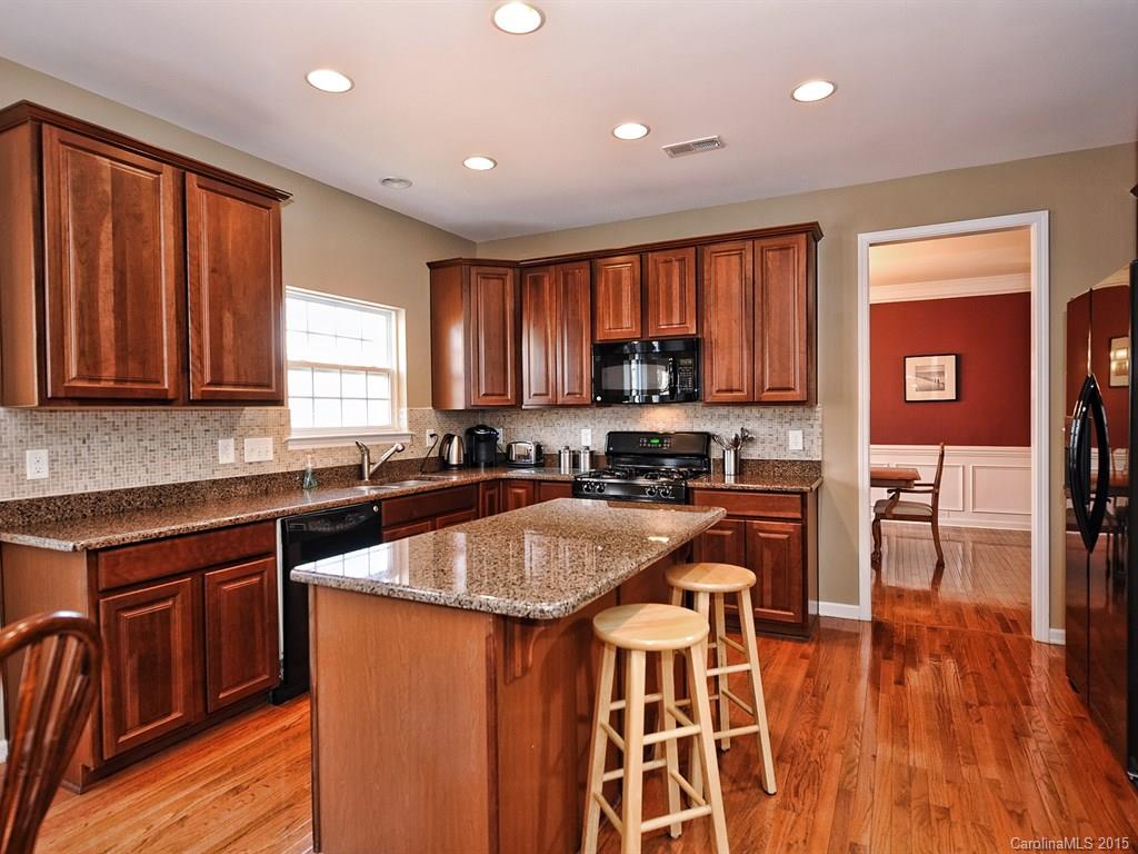 1953 Faison Avenue Fort Mill, SC 29708 - Photo 8 of 24 a kitchen with stainless steel appliances granite countertop a sink a stove a refrigerator cabinets and a dining table