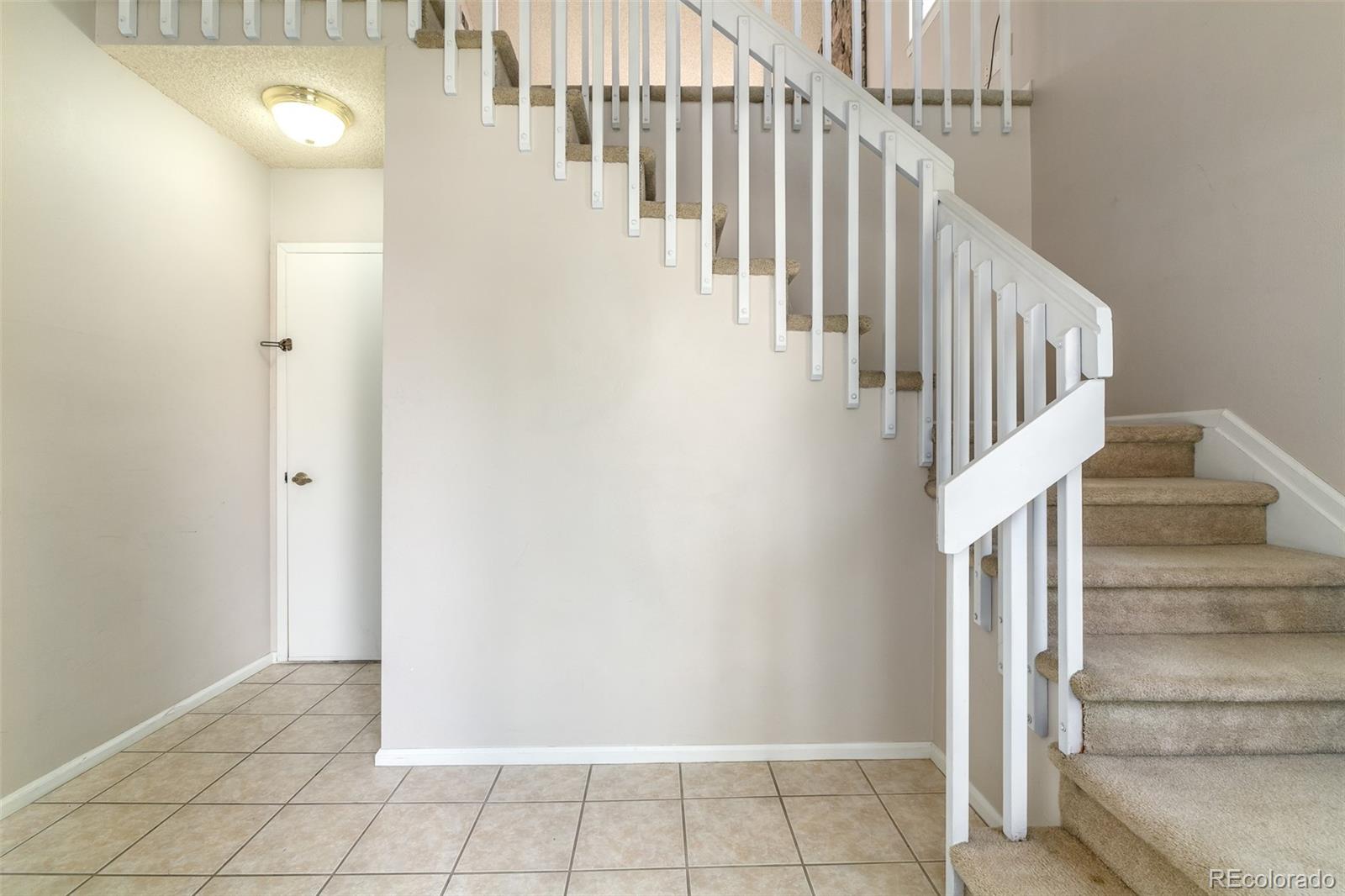 8449 Everett Way, Unit E Arvada, CO 80005 - Photo 3 of 25 a view of staircase with white walls and white walls