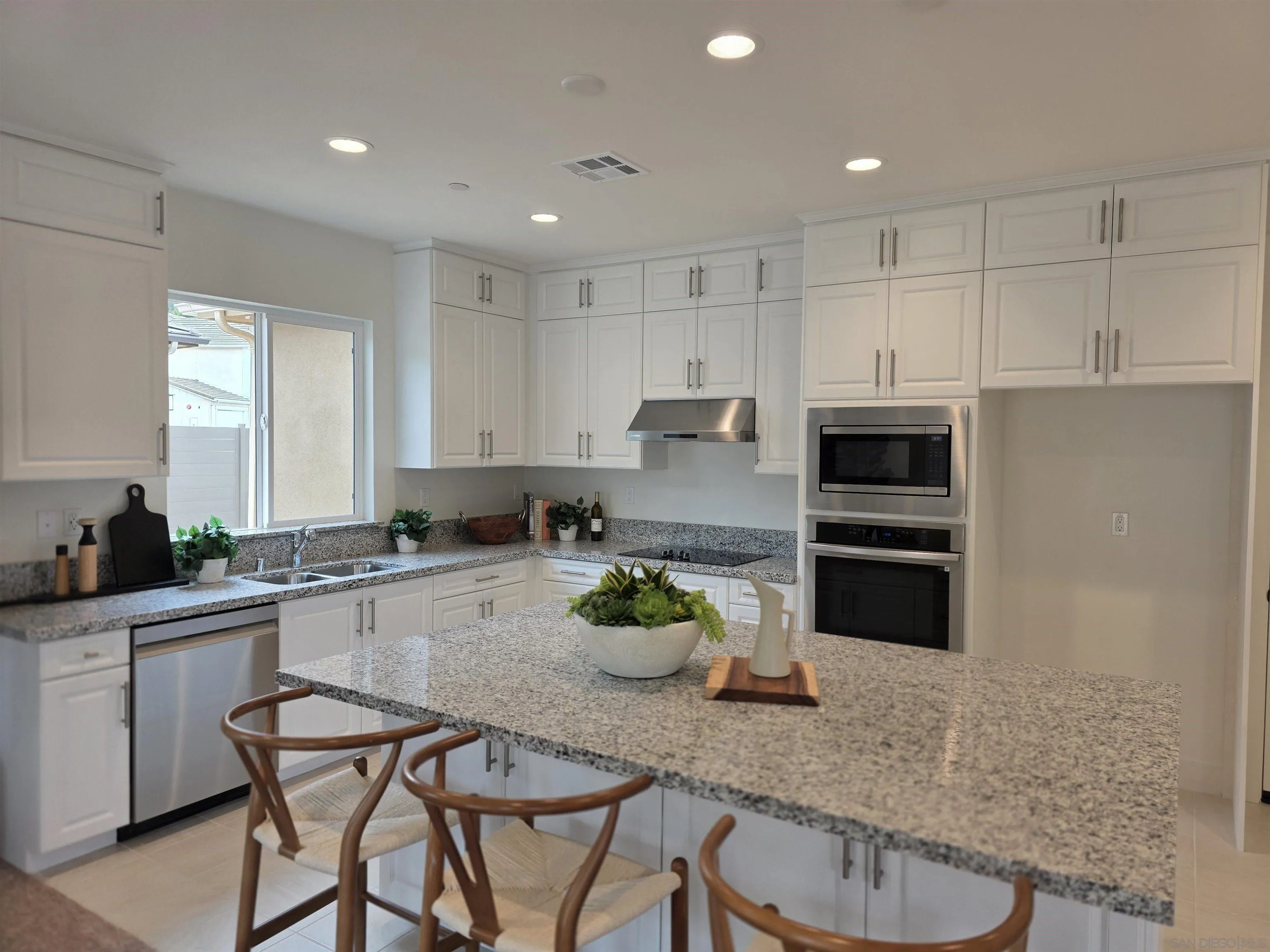 3140 Smith Place Escondido, CA 92027 - Photo 7 of 19 a kitchen with stainless steel appliances a sink a stove a table and chairs in it