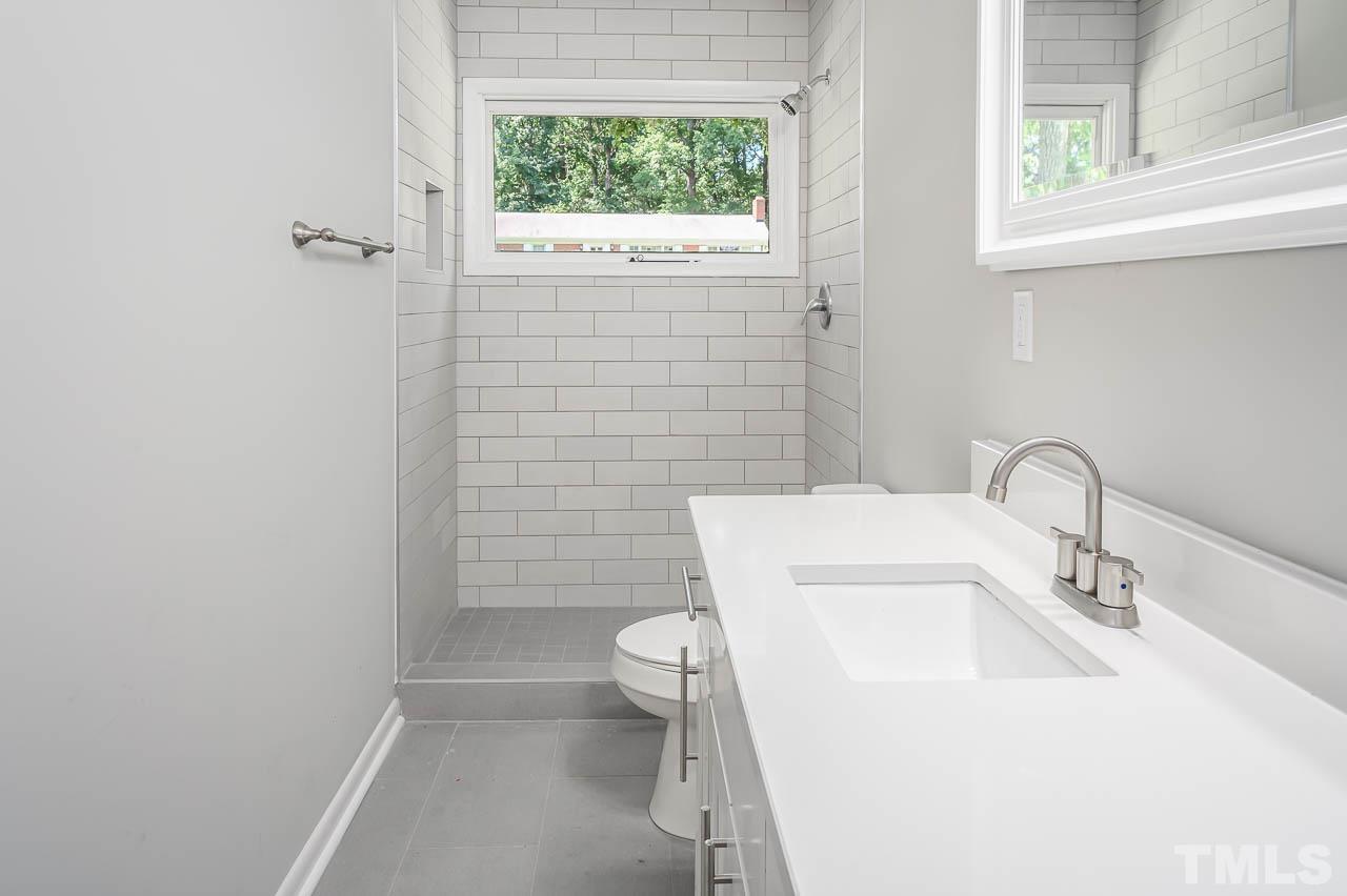 3401 Forest Road Raleigh, NC 27604 - Photo 25 of 30 a bathroom with a sink a toilet and a mirror
