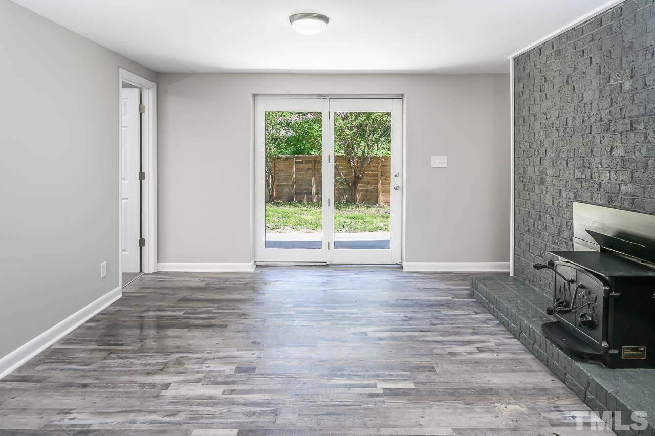 3401 Forest Road Raleigh, NC 27604 - Photo 5 of 30 a view of a livingroom with a flat screen tv wooden floor and a window
