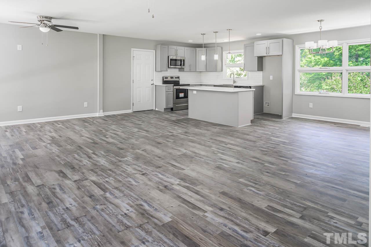 3401 Forest Road Raleigh, NC 27604 - Photo 8 of 30 a room with kitchen island granite countertop wooden floors and wide window