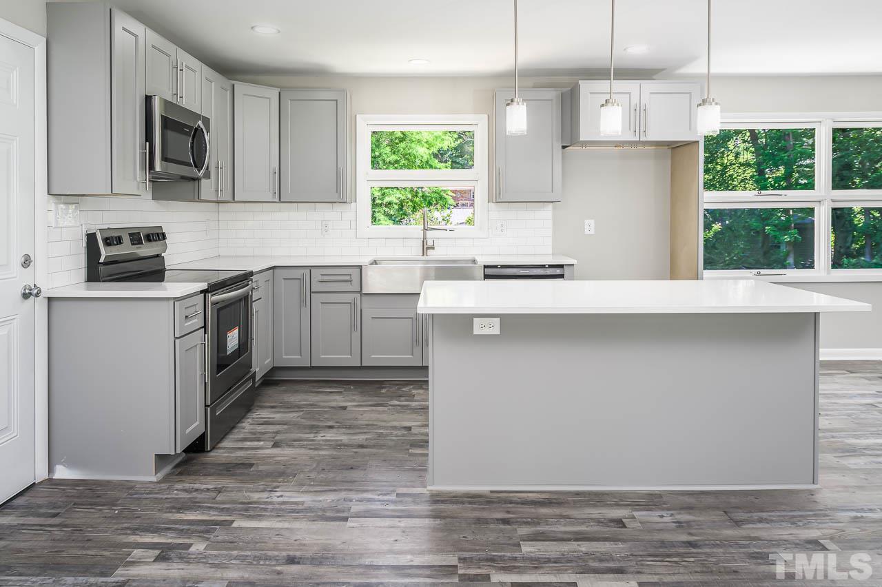 3401 Forest Road Raleigh, NC 27604 - Photo 9 of 30 a kitchen with stainless steel appliances granite countertop a stove a sink and a microwave