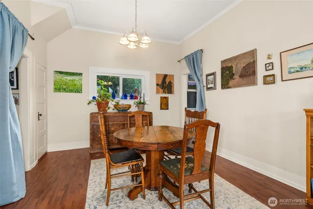 a view of a dining room with furniture a chandelier and wooden floor
