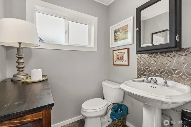 a bathroom with a toilet a sink and mirror