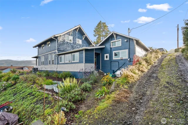 a front view of a house with a garden and plants